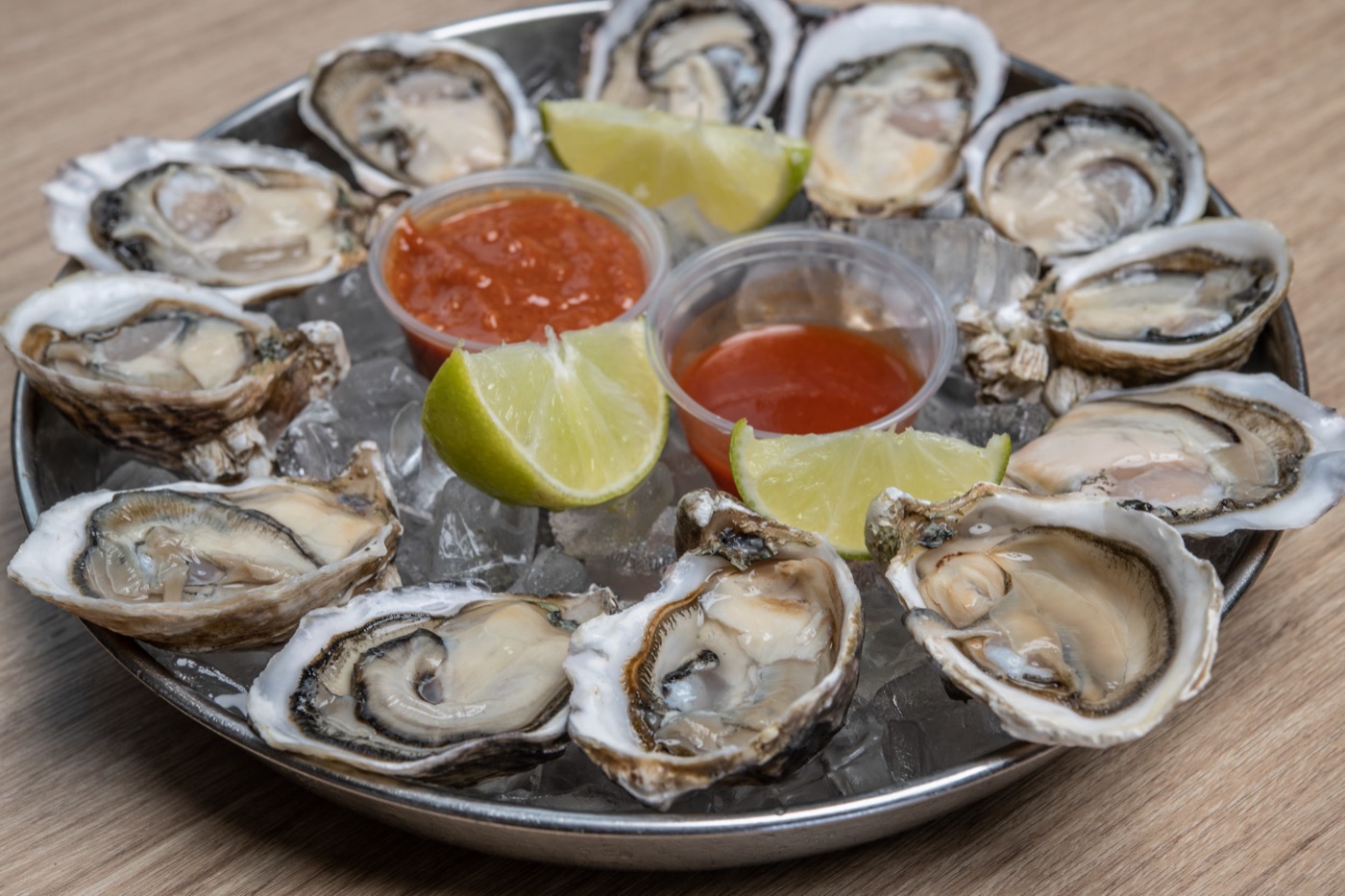A dozen raw oysters on the half shell with lemon and cocktail sauce.